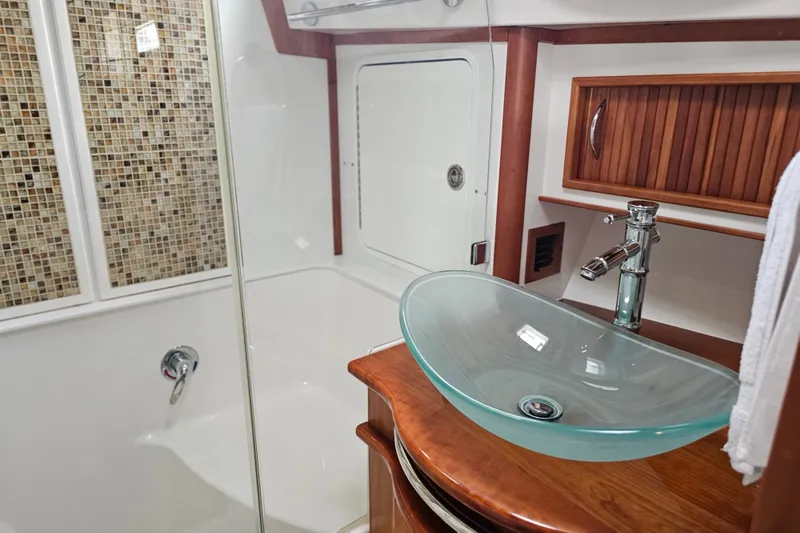 Slide: The Image of Luxurious bathroom in 2013 Sabre 48 Salon Express yacht with glass sink and wood accents. - 38