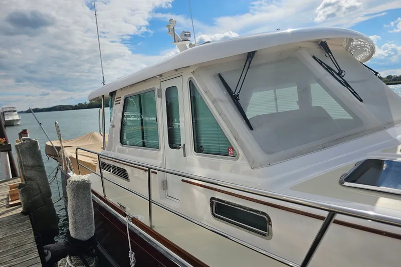 Slide: The Image of 2013 Sabre 48 Salon Express yacht docked by the water under a partly cloudy sky. - 4