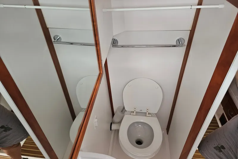 Slide: The Image of Bathroom interior of 2013 Sabre 48 Salon Express yacht, featuring a toilet and mirror. - 56