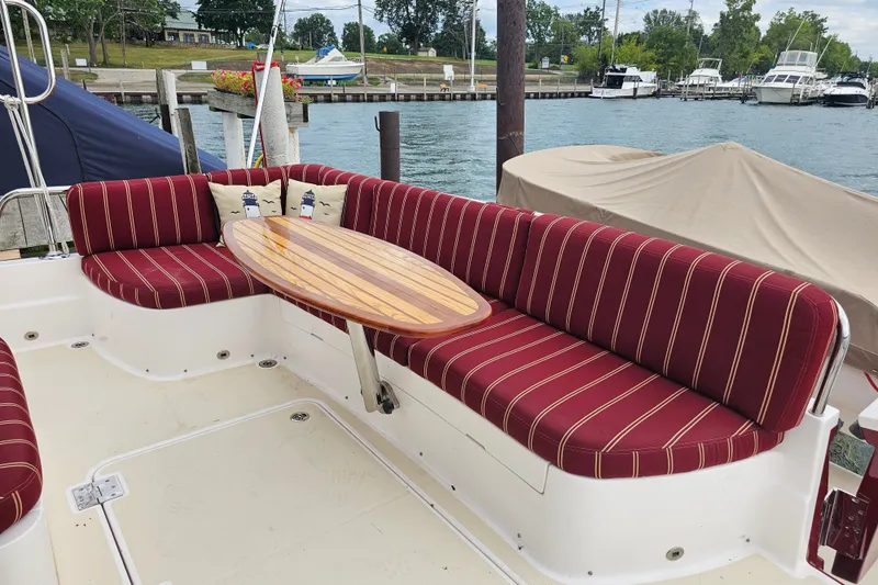 Slide: The Image of 2013 Sabre 48 Salon Express yacht with red-striped seating and wooden table on deck. - 7