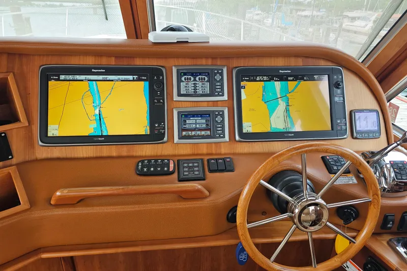 Slide: The Image of 2013 Sabre 48 Salon Express helm with dual Raymarine displays and wooden steering wheel. - 18