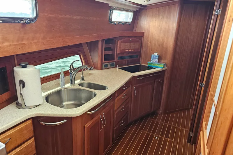Slide: The Image of Luxurious 2013 Sabre 48 Salon Express yacht kitchen with wooden cabinetry and dual sinks. - 32
