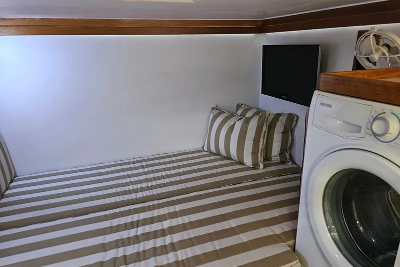 Slide: The Image of Cozy cabin interior of 2013 Sabre 48 Salon Express with striped bedding and washer. - 53