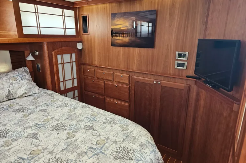 Slide: The Image of Luxurious 2013 Sabre 48 Salon Express cabin with wood paneling and cozy bedding. - 36
