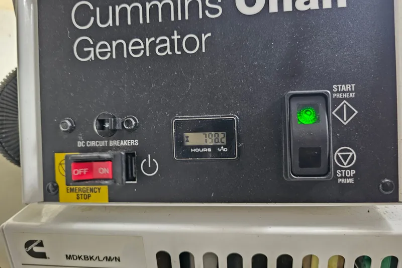 Slide: The Image of Cummins Onan generator control panel with hour meter and emergency stop switch. - 62