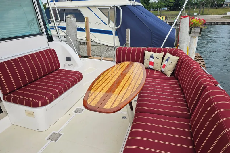 Slide: The Image of 2013 Sabre 48 Salon Express yacht with striped seating and wooden table on deck. - 8