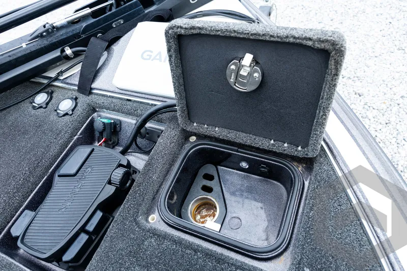 Slide: The Image of 2015 Legend V-20 boat compartment with Garmin pedal and open storage hatch. - 20
