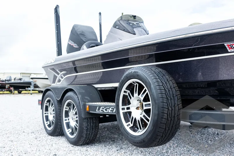 Slide: The Image of 2015 Legend V-20 boat on trailer with stylish wheels, parked on gravel. - 10