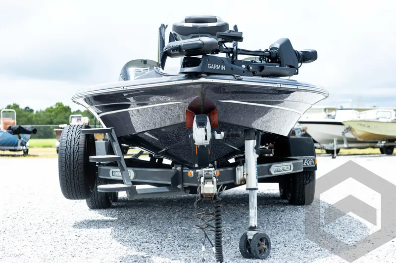 Slide: The Image of 2015 Legend V-20 boat on trailer with Garmin equipment, parked on gravel. - 2