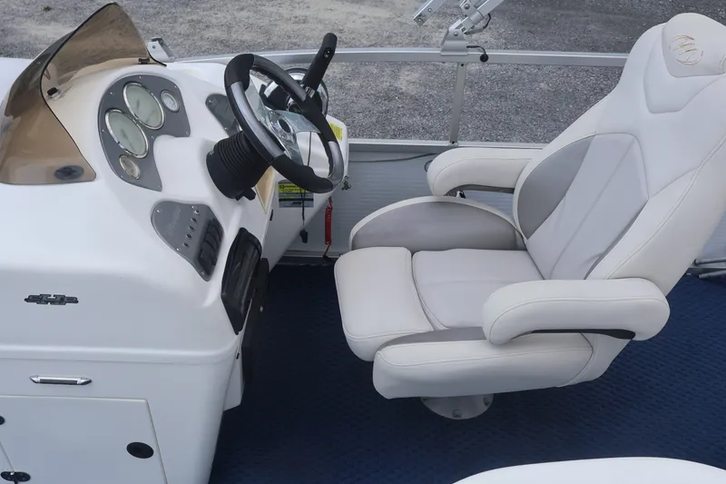 Slide: The Image of 2007 Manitou 22 Oasis boat helm with steering wheel and comfortable captain's chair. - 44