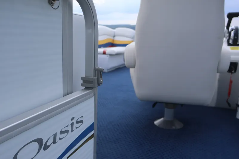 Slide: The Image of Interior of a 2007 Manitou 22 Oasis boat with blue carpet and white seating. - 26