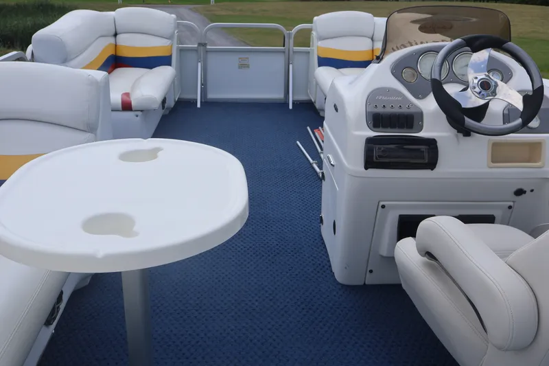 Slide: The Image of 2007 Manitou 22 Oasis pontoon boat interior with blue carpet and white seating. - 34