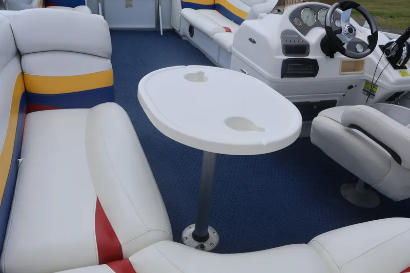 Slide: The Image of 2007 Manitou 22 Oasis boat interior with white seating, table, and steering console. - 39