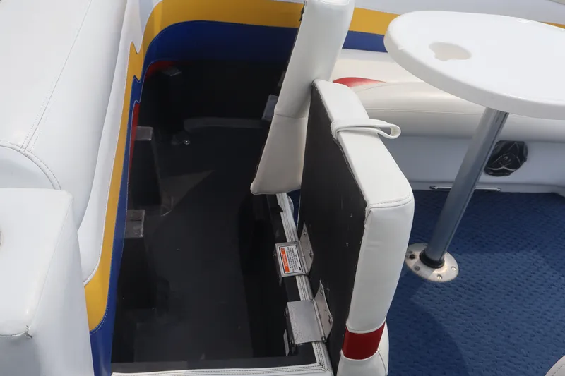 Slide: The Image of Interior seating and table of a 2007 Manitou 22 Oasis boat, featuring colorful upholstery. - 40