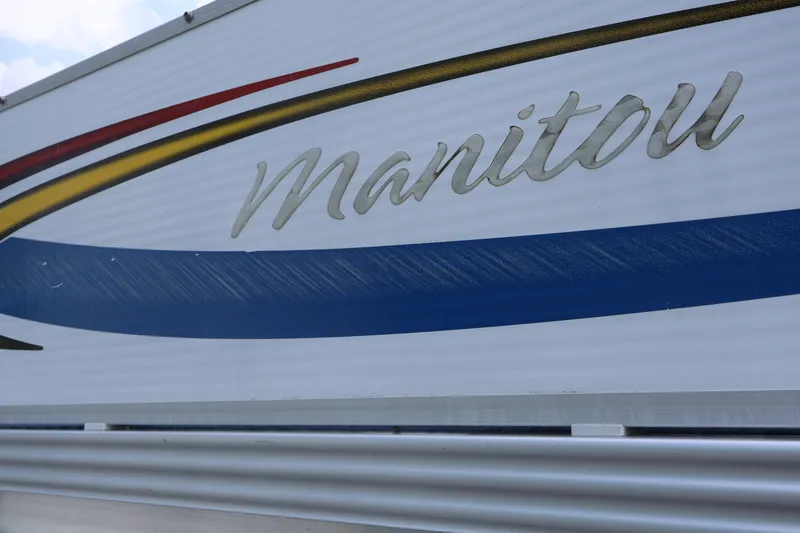 Slide: The Image of 2007 Manitou 22 Oasis boat logo with colorful design accents. - 17