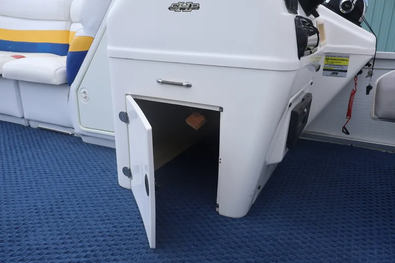 Slide: The Image of Open storage compartment on 2007 Manitou 22 Oasis boat with blue carpet flooring. - 50