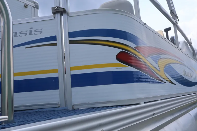 Slide: The Image of 2007 Manitou 22 Oasis boat with colorful side graphics and sleek design. - 22