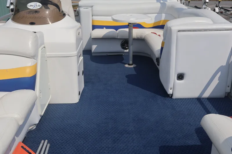 Slide: The Image of Interior of a 2007 Manitou 22 Oasis boat with blue carpet and white seating. - 62