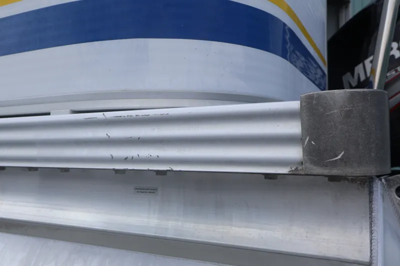 Slide: The Image of Close-up of a 2007 Manitou 22 Oasis boat's metal railing with blue and yellow accents. - 25
