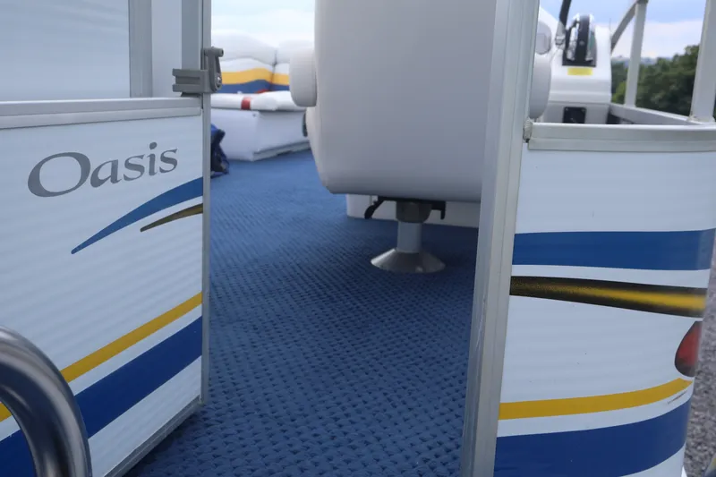 Slide: The Image of 2007 Manitou 22 Oasis boat interior with blue carpet and colorful side design. - 27