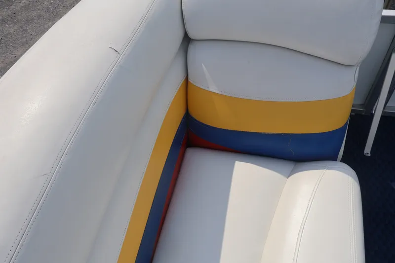 Slide: The Image of 2007 Manitou 22 Oasis boat seat with colorful upholstery in white, yellow, and blue. - 59