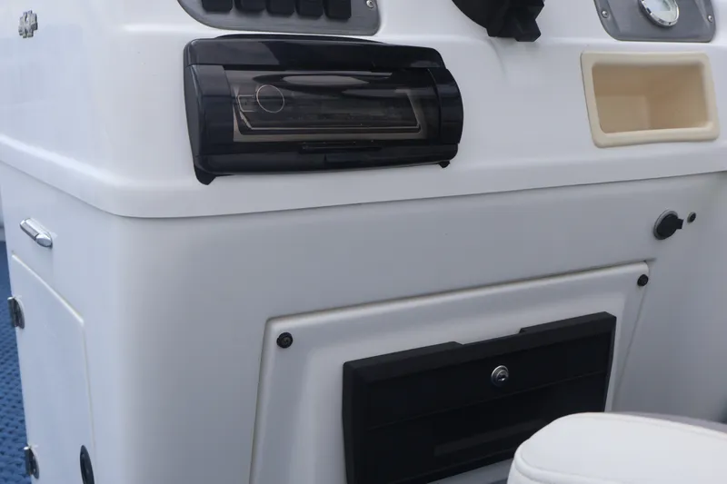Slide: The Image of 2007 Manitou 22 Oasis boat dashboard with stereo system and storage compartments. - 49