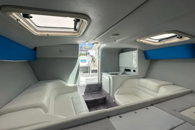 Slide: The Image of Interior of a 2000 Formula 271 FASTech boat with white seating and compact kitchenette. - 15