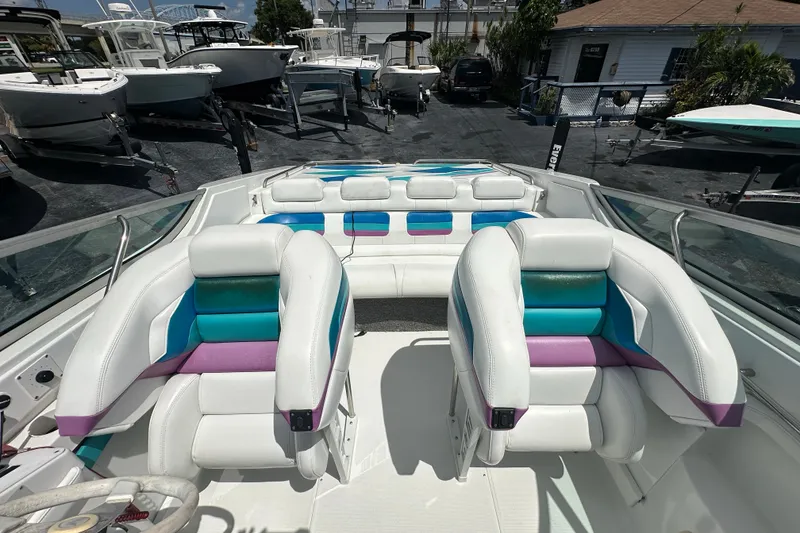 Slide: The Image of 2000 Formula 271 FASTech boat interior with colorful seating, docked among other boats. - 11