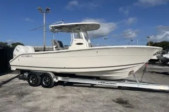 Slide: The Image of 2024 Cobia 262 Center Console boat on trailer under clear blue sky. - 5