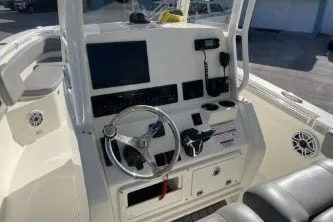 Slide: The Image of 2024 Cobia 262 Center Console boat dashboard with steering wheel and electronic controls. - 9