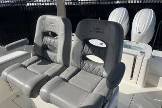 Slide: The Image of 2024 Cobia 262 Center Console boat seats with dual outboard motors in the background. - 12