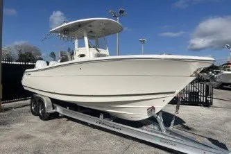 Slide: The Image of 2024 Cobia 262 Center Console boat on trailer under clear blue sky. - 4