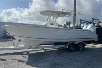 The Image of 2024 Cobia 262 Center Console boat on trailer under cloudy sky. - 1