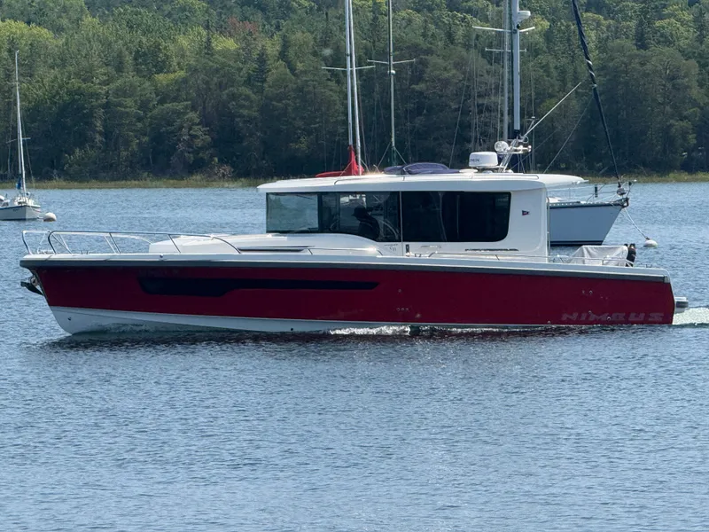 Slide: The Image of A red Nimbus Commuter 11 boat from 2024 cruising on calm waters. - 2