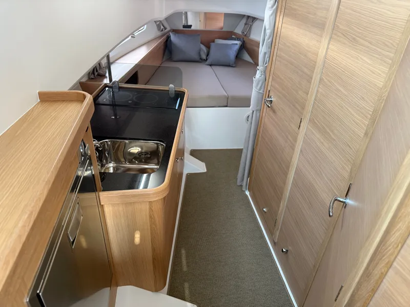 Slide: The Image of Interior of the 2024 Nimbus Commuter 11 featuring a kitchenette and sleeping area. - 12
