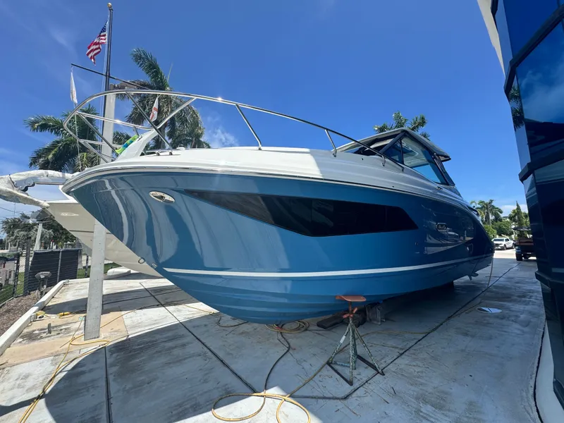 Slide: The Image of A 2027 Sea Ray Sundancer 320 Outboard is on a dock. The sky is clear and blue. - 0