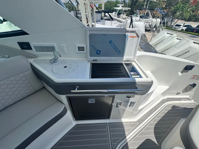 Slide: The Image of The 2027 Sea Ray Sundancer 320 Outboard features an outdoor kitchen with a grill and sink. - 6