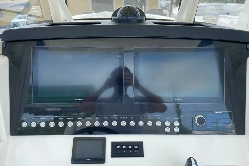 Slide: The Image of 2022 Regulator 34 boat dashboard with dual Garmin displays and control panel. - 43