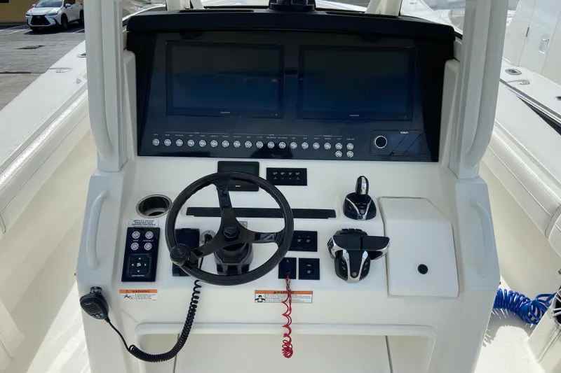Slide: The Image of Control panel of a 2022 Regulator 34 boat with steering wheel and navigation screens. - 40