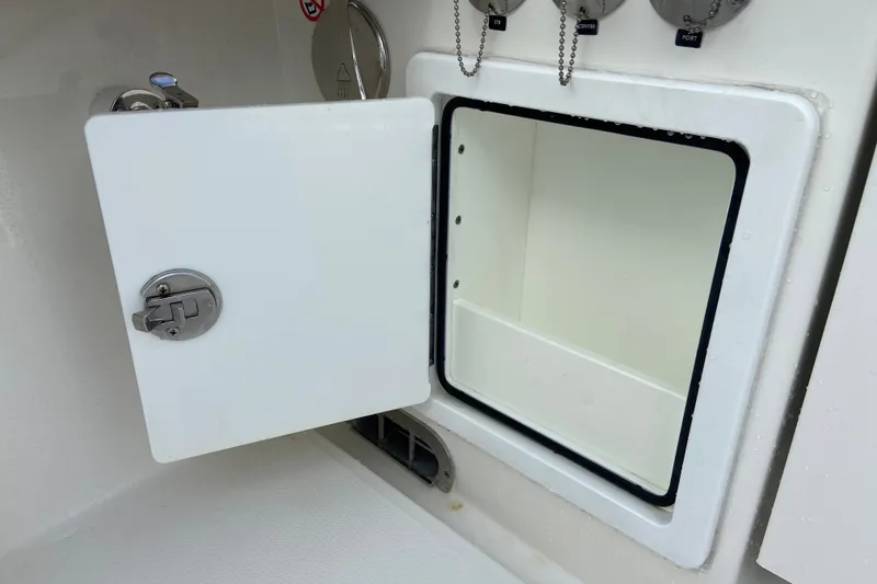 Slide: The Image of Open storage compartment on 2022 Regulator 34 boat, featuring a secure latch and clean interior. - 21