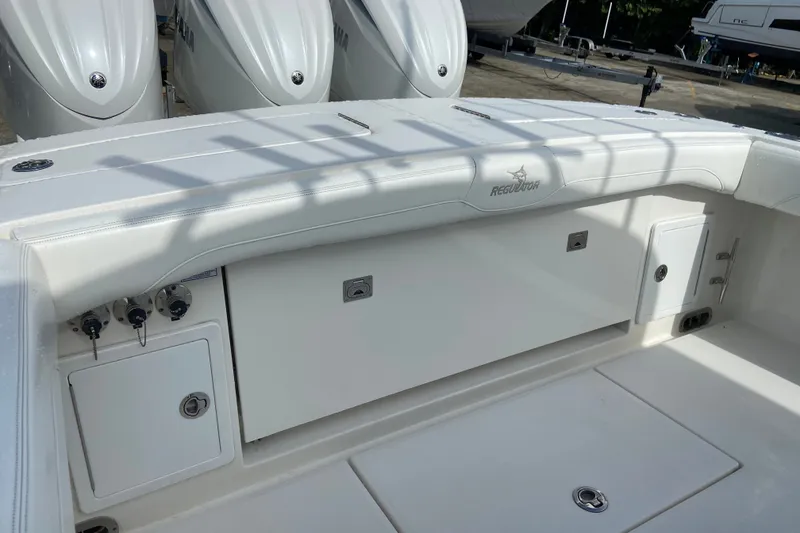 Slide: The Image of 2022 Regulator 34 boat deck with storage compartments and Yamaha engines in background. - 15