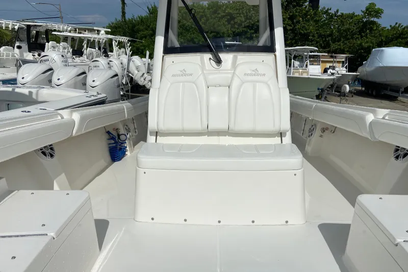 Slide: The Image of 2022 Regulator 34 boat interior with white seating and Yamaha engines in background. - 57
