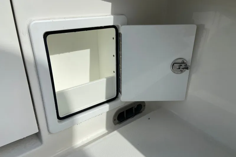 Slide: The Image of Open storage compartment on a 2022 Regulator 34 boat, featuring a secure latch. - 23