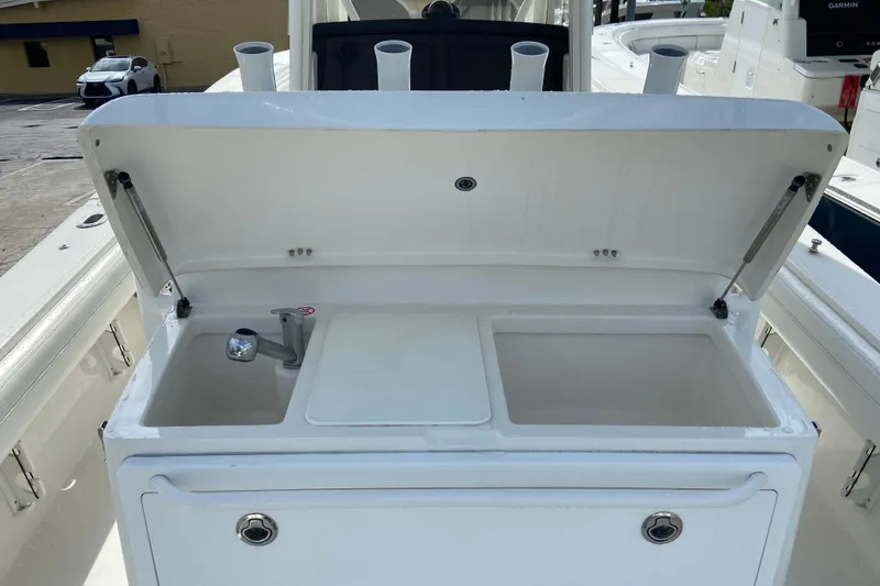 Slide: The Image of 2022 Regulator 34 boat sink and storage compartment with open lid. - 30