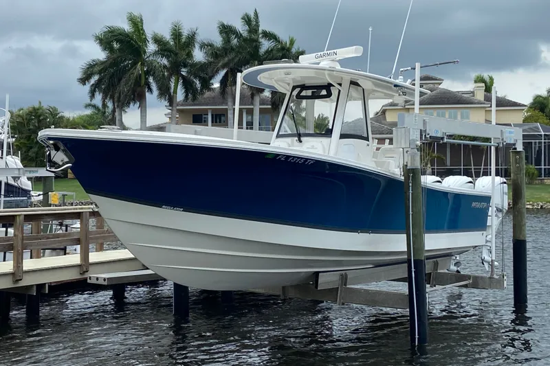 Slide: The Image of 2022 Regulator 34 boat docked, featuring a sleek blue and white design. - 11