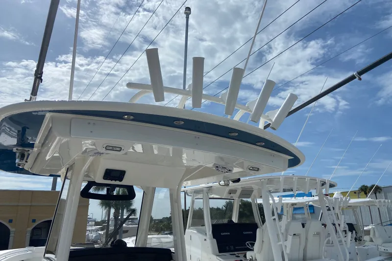 Slide: The Image of 2022 Regulator 34 boat with rod holders and electronics under a clear blue sky. - 36