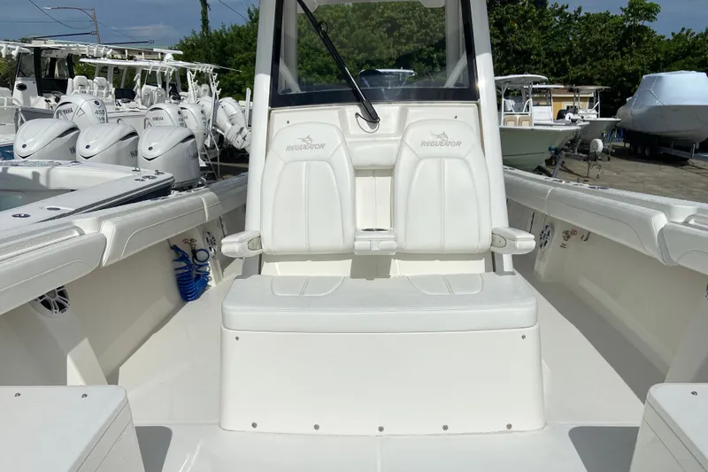Slide: The Image of 2022 Regulator 34 boat interior with dual seats and Yamaha engines in the background. - 58
