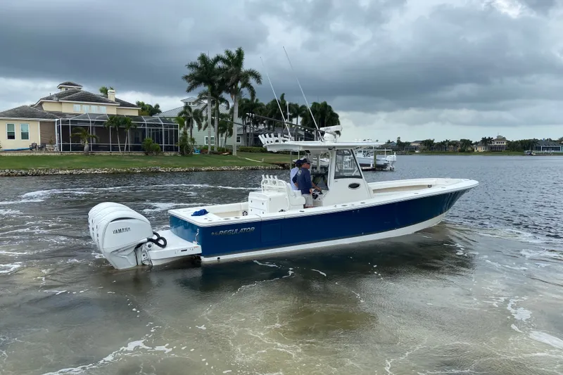 Slide: The Image of 2022 Regulator 34 boat with Yamaha engine on a calm waterfront. - 3