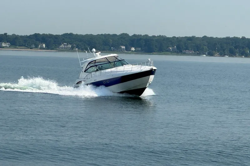 The Image of 2006 Cruisers Yachts 520 Express cruising on a calm lake with scenic shoreline. - 0