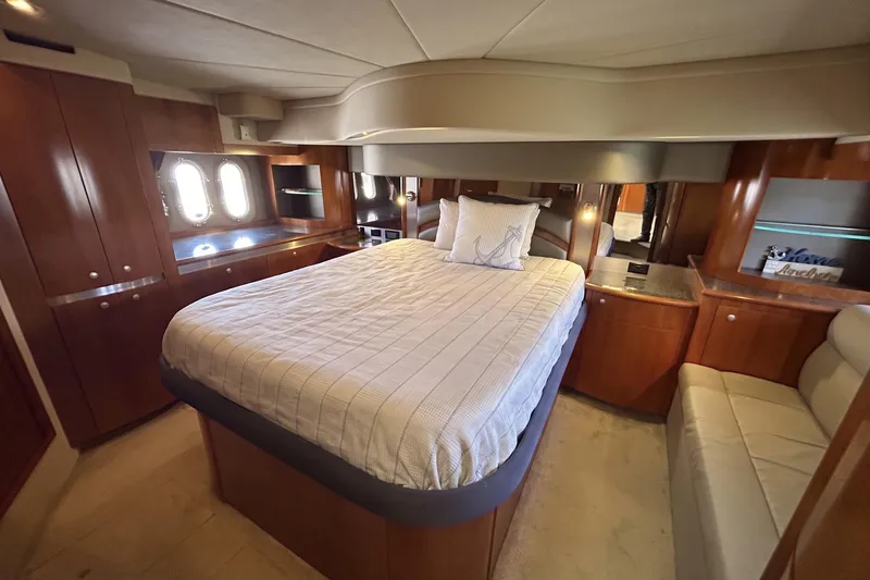 Slide: The Image of Luxurious 2006 Cruisers Yachts 520 Express bedroom with elegant wood cabinetry and plush bedding. - 29